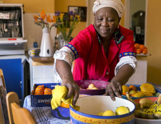 Woman in a red dress preparing fresh fruit in her kitchen